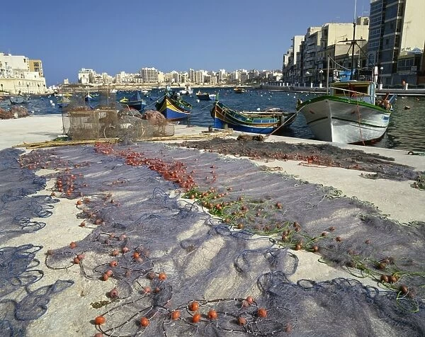 Fishing nets drying in the sun in St. Julians Bay, Malta, Mediterranean, Europe