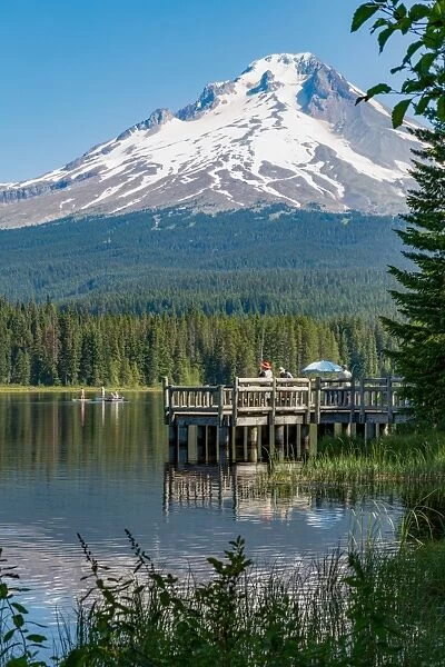 Fishing on Trillium Lake with Mount Hood, part of the Cascade Range, reflected in the still waters