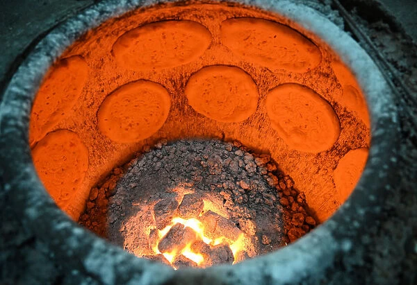 Flatbreads cooking in flatbread oven in Turfan street night market, Turfan, Xinjiang
