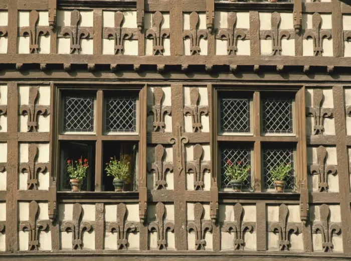 Framed Print : Detail of fleur-de-lys motif carved in wood on the timber framed Market Hall in the village of Arreau, Midi-Pyrenees
