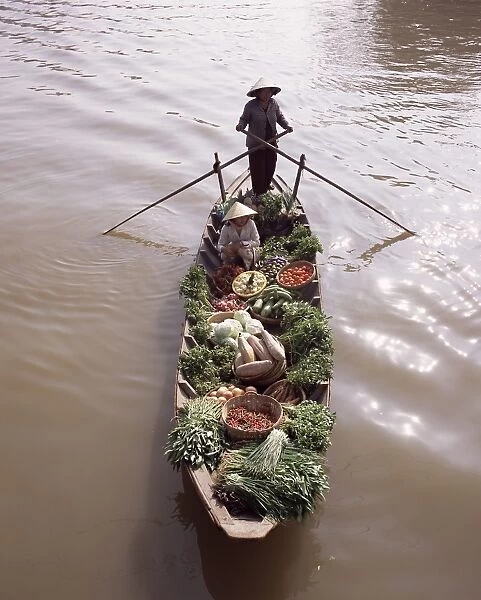Floating market trader and boat laden with vegetables