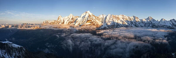 Foggy sky at sunset over majestic rocks of Eiger, Monch and Jungfrau mountains