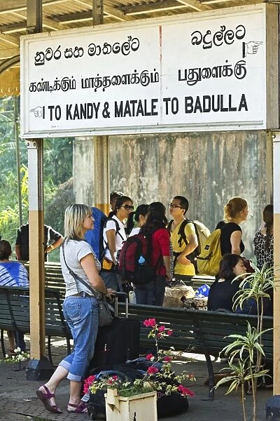 Foreign travellers await the popular Colombo to Badulla train at the railway station at Peradeniya