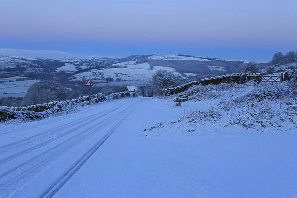 Fresh snow on country lane, winter pre-dawn blue hour, below Curbar Edge, Peak District National Park, Derbyshire, England, United Kingdom, Europe