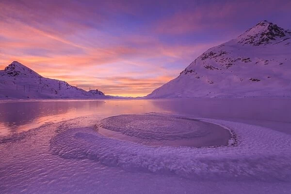 Frost creating unusual shapes in the middle of Lake Bianco at Bernina illuminated by the light of sunrise, Graubunden, Swiss Alps, Switzerland, Europe