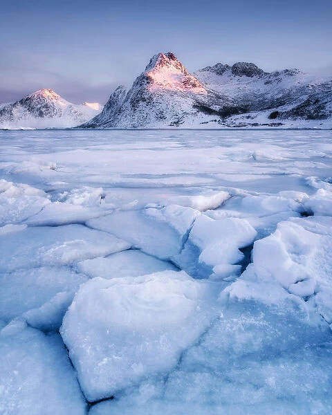 Frozen lake in front of mountain in the early morning light, Lofoten Islands, Nordland