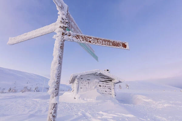 Frozen signage and wood hut, Pallas-Yllastunturi National Park, Muonio, Lapland, Finland