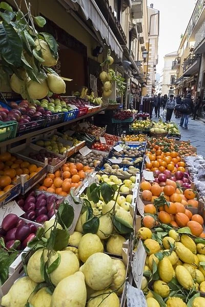 Fruit, including local lemons and oranges, displayed outside a shop in a narrow street