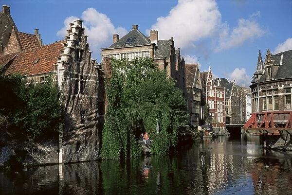 Gabled buildings with distorted facade of bricks, beside old canal, north of the centre of Ghent