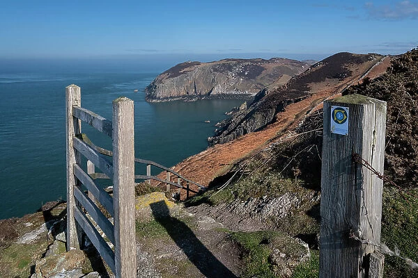 Gate and coast path sign framing Llanlleiana Head on The Anglesey Coastal Path, near Cemaes, Anglesey, North Wales, United Kingdom, Europe