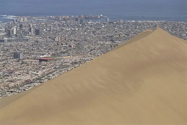 Giant sand dune above large city, Iquique, Atacama coast, Chile, South America