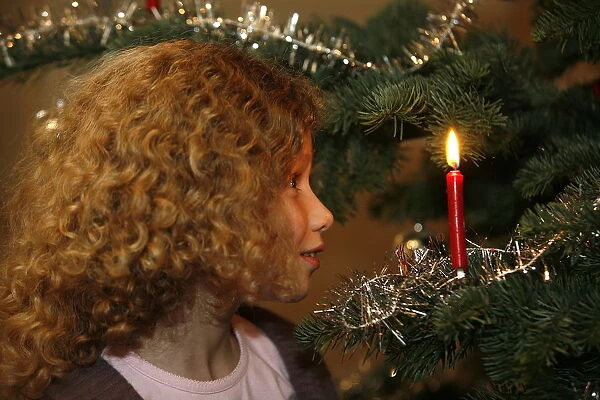 Girl looking at Christmas tree, Haute Savoie, France, Europe