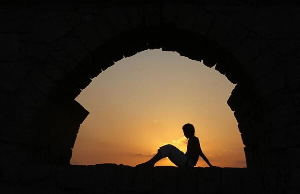 Girl watching sunset in Cesarea, Israel, Middle East