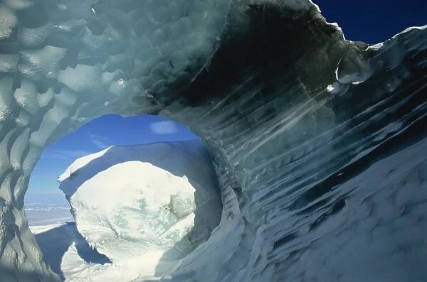 Glacial meltwater tunnel in iceberg showing sculpted water flow patterns