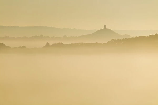 Glastonbury Tor and surrounding hills rising above early morning mist, Glastonbury
