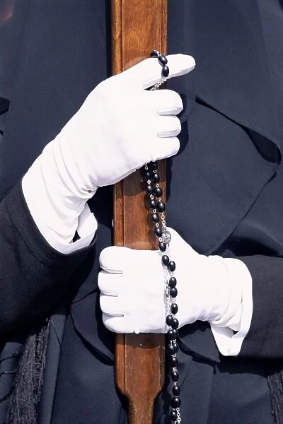 Gloved hands with rosary