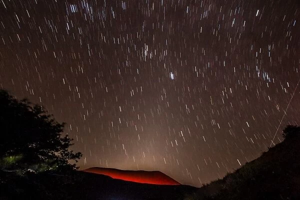 Glowing active volcanic crater of Volcan Telica at night with star trails and shooting star (meteor) on right, Leon, Nicaragua, Central America