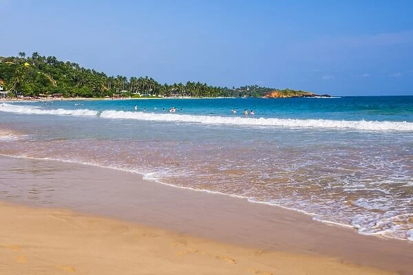 Golden sands and blue waters of the Indian Ocean at Mirissa Beach, South Coast, Sri Lanka, Asia