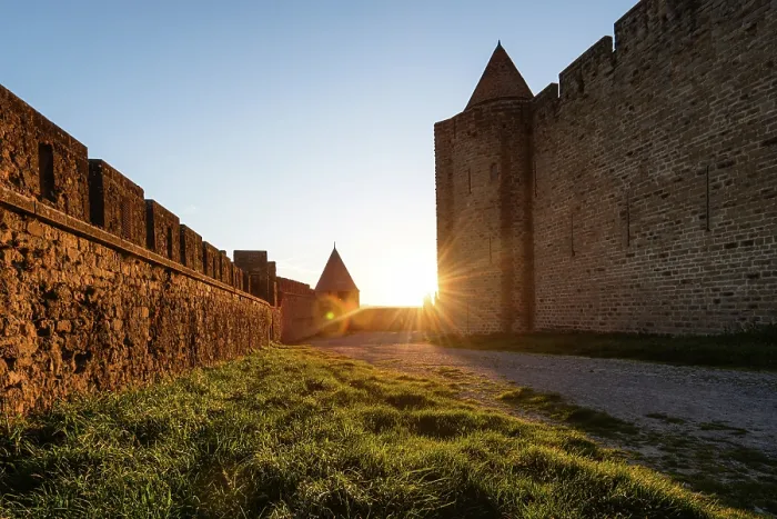 Framed Print : Golden Sunburst Framed by the Towering Stone Fortifications of Carcassonne at Dusk Along a Medieval Path Framed Print : Golden Sunburst Framed by the Towering Stone Fortifications of Carcassonne at Dusk Along a Medieval Path