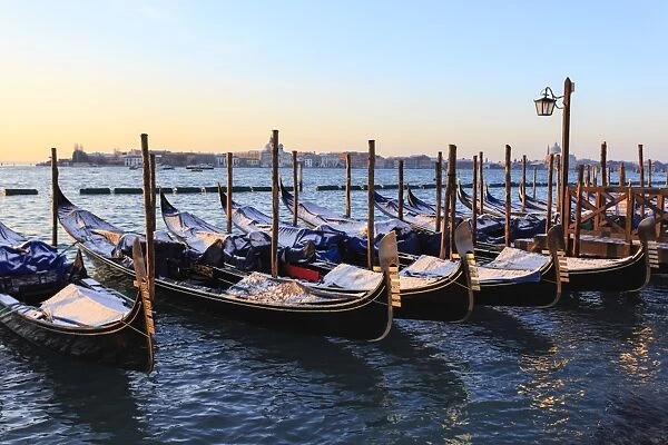 Gondolas covered in snow with view to La Guidecca, sunrise, Venice, UNESCO World Heritage Site