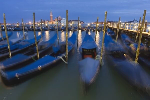 Gondolas on waterfront at night