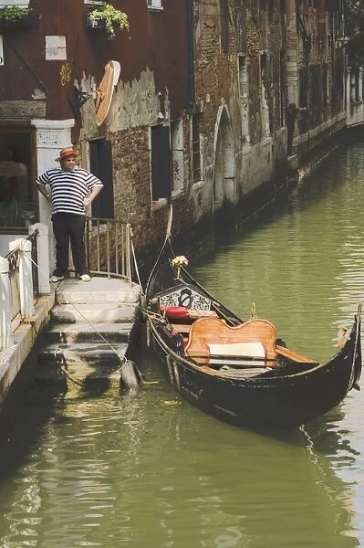 Gondolier and gondola for hire on canal