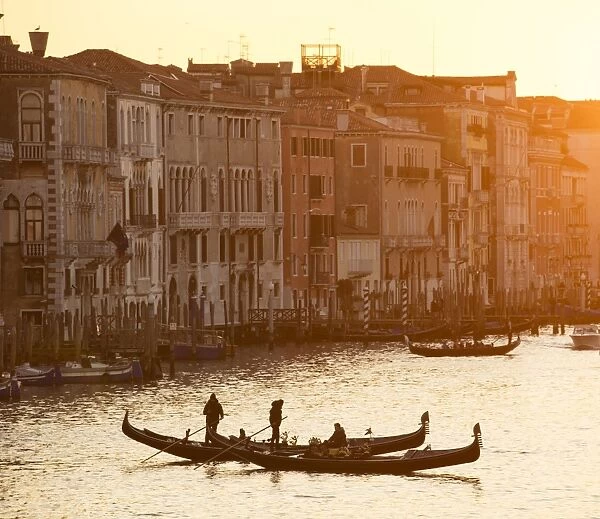 Two gondoliers in silhouette at sunset on the Grand Canal, from Rialto Bridge, Venice