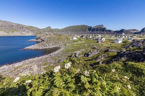 Green meadows frame the village of Sorland surrounded by sea, Vaeroy Island, Nordland county
