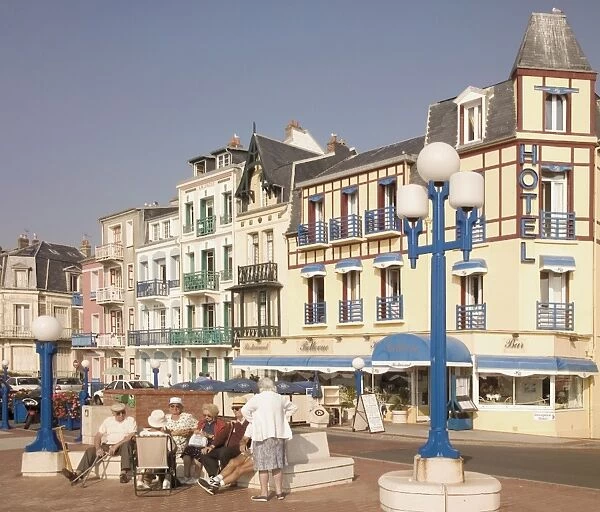 Group of elderly people sitting on seafront in the restort town of Mers les Bains