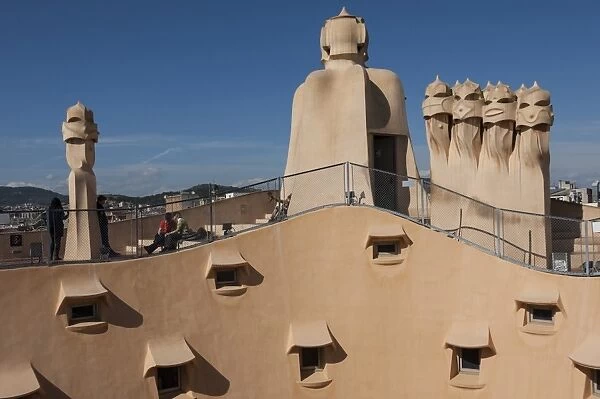 Group of four grotesque chimneys on the roof of La Pedrera (Casa Mila), and roof window details on an apartment block designed by Antonio Gaudi, UNESCO World Heritage Site, Passeig de Gracia, Barcelona, Catalunya, Spain, Europe