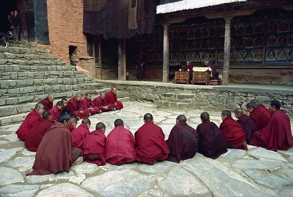 A group of young novice monks sitting in a circle during an oral examination