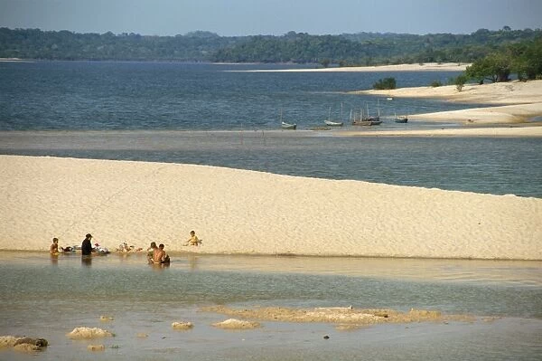 Groups of people and boats on the sand spit beaches at Alter do Chao on the Tapajos River in the Amazon area of Brazil