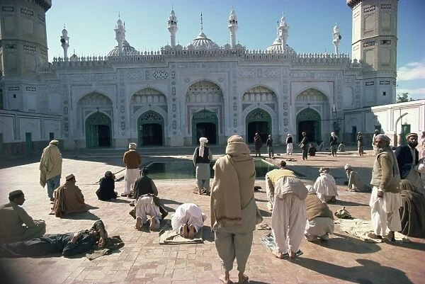 Groups of people praying outside the Mahabat Khan Mosque