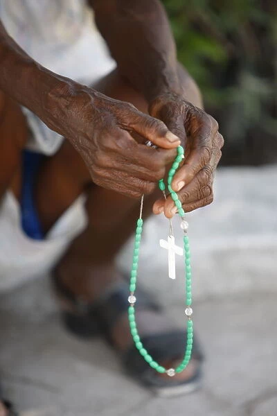 Haitian woman praying with prayer beads, Port au Prince, Haiti, West Indies