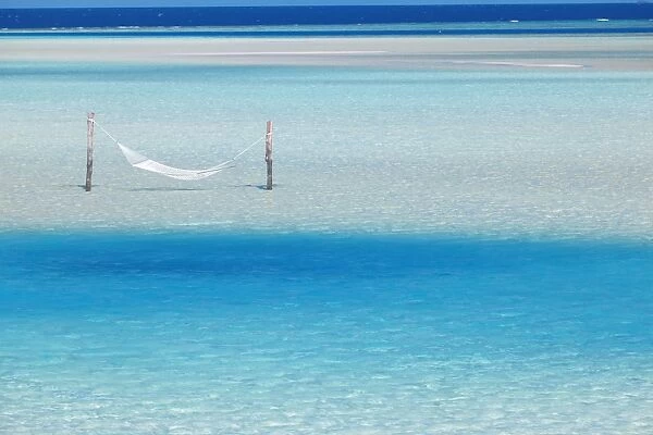 Hammock hanging in shallow clear water, Maldives, Indian Ocean, Asia