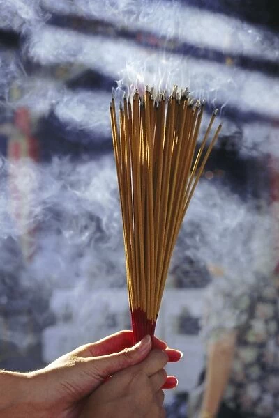 Hand holding incense, Hong Kong, China, Asia