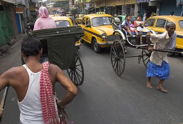 Hand pulled rickshaws and yellow taxis
