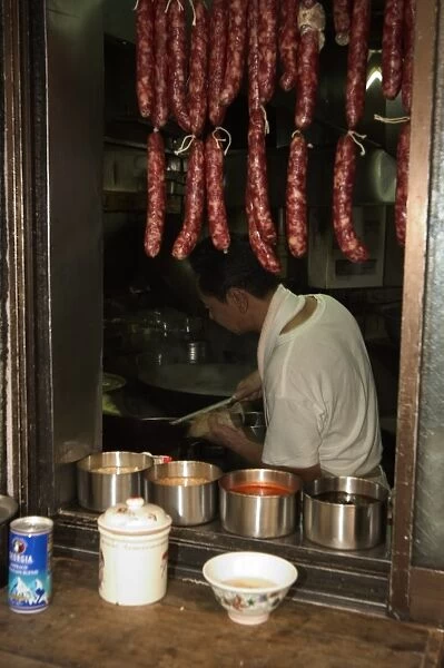 Hanging sausages in window of restaurant kitchen