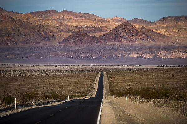 Highway through Death Valley with mountains in the distance, California, United States of America