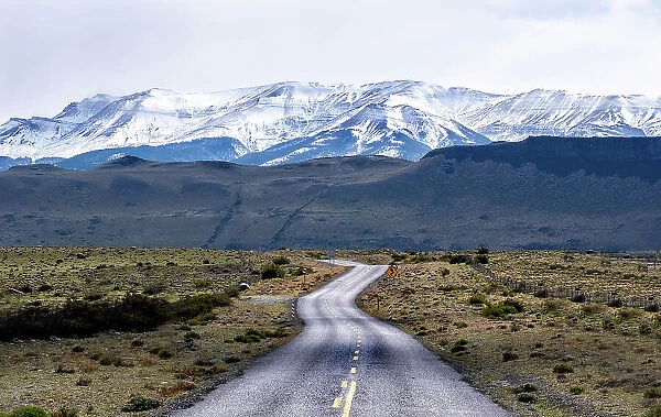 Highway leading to snow covered mountains, Torres del Paine National Park, Chile, South America