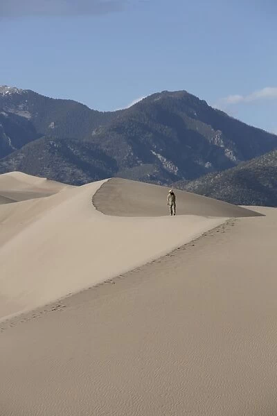 Hiker on the sand dunes, Great Sand Dunes National Park and Preserve, with Sangre Cristo Mountains in the background, Colorado, United States of America, North America