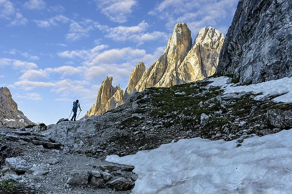 Hiker woman walking on path to majestic Croda Dei Toni mountain at dawn, Val Fiscalina