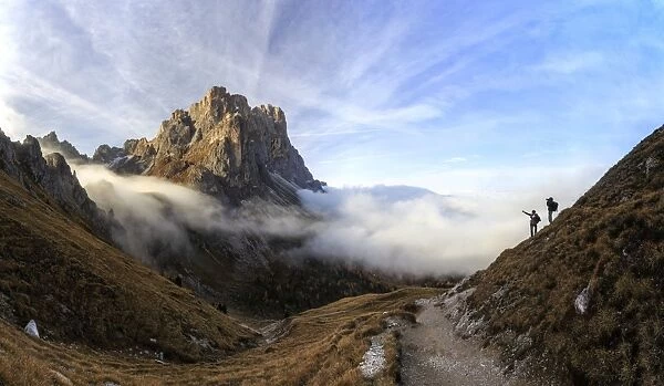 Hikers admire the peaks of Forcella De Furcia at sunrise, Funes Valley, South Tyrol
