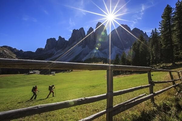 Hikers proceed from Glatsch Alm with Odle in background, Funes Valley, South Tyrol