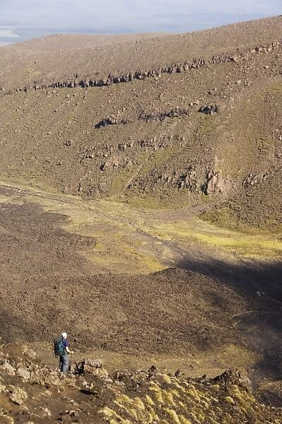 Hikers walking through a lava field on the Tongariro Crossing