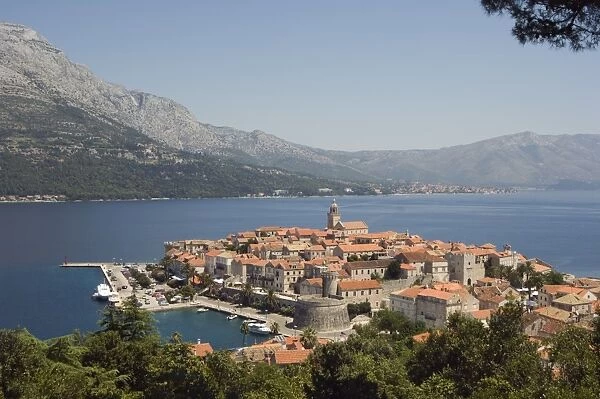 Hilltop view of red tile rooftops of medieval Old Town and Bay, Korcula Island