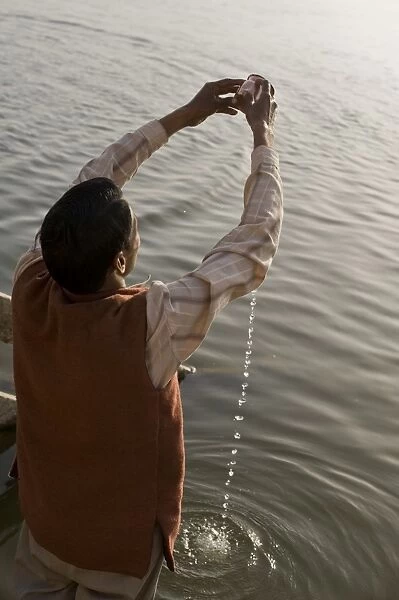 Hindu performing his daily devotion ritual to Ganga in Varanasi, Uttar Pradesh