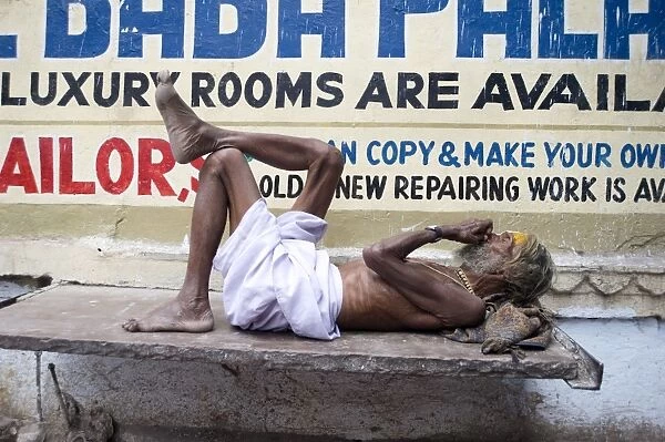 Holy man (Saddhu) resting on a marble slab, Udaipur, Rajasthan, India, Asia
