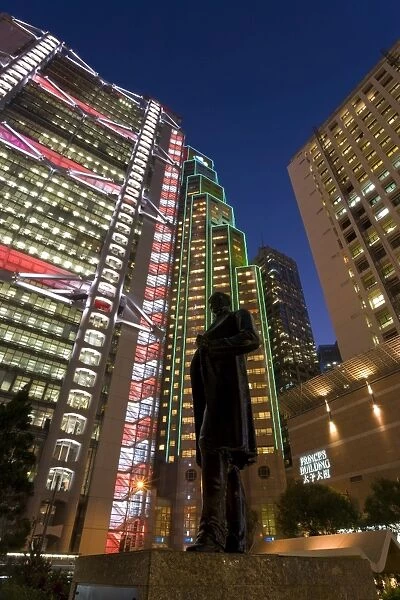 Hong Kong and Shanghai Bank illuminated at dusk behind statue of Sir Thomas Jackson