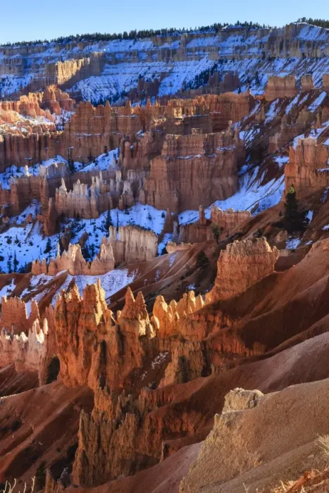 Framed Print : Hoodoos and snowy rim cliffs lit by strong late afternoon sun in winter, near Sunrise Point, Bryce Canyon National Park, Utah, United States of America, North America